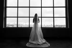 bw photo of bride by the window